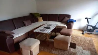 a living room with a couch and a table and chairs at Apartman Suzana in Kupres