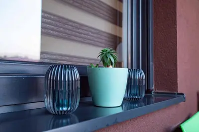 three vases sitting on a window sill with a plant at Apartman Royal 3 in Doboj