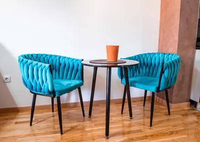 two blue chairs and a table with a vase on it at Apartman Royal 3 in Doboj