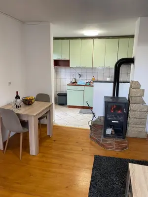 a kitchen with a table and a stove in a room at Apartman Antonia in Kupres