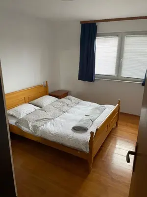 a bedroom with a large bed with a blue curtain at Apartman Antonia in Kupres