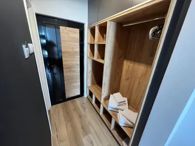 a small bathroom with wooden shelves and a door at Business Hotel Prijedor in Prijedor