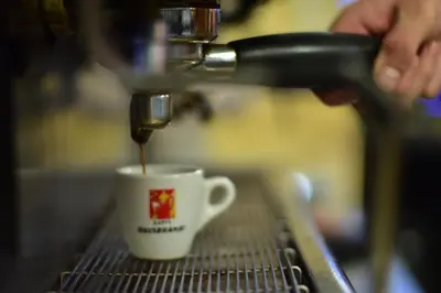 a person is making a cup of coffee at Business Hotel Prijedor in Prijedor