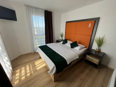 a bedroom with a large bed and a large window at Business Hotel Prijedor in Prijedor