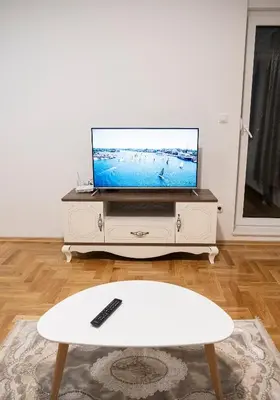 a living room with a flat screen tv on a dresser at Apartman Venezia in Banja Luka