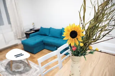 a vase with a sunflower on a table in a living room at Apartman Venezia in Banja Luka
