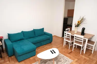 a living room with a blue couch and a table at Apartman Venezia in Banja Luka