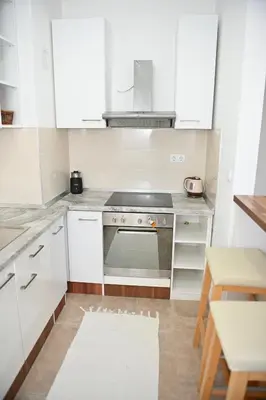 a kitchen with white cabinets and a stove at Apartman Giljen in Teslić