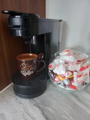 a coffee maker with a cup and a bowl of marshmallows at Apartman Giljen in Teslić