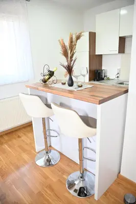 a kitchen with a counter and two bar stools at Apartman Giljen in Teslić