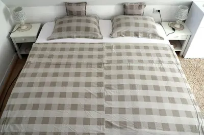 a bed with a checkered blanket on top of it at Holiday Home Ravne in Visoko