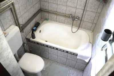 a small bathroom with a toilet and a bath tub at Holiday Home Ravne in Visoko