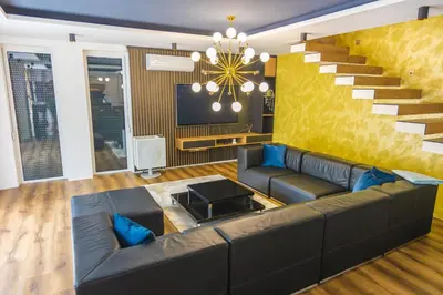 a living room with a couch and a staircase at Lohovo Villa Bukva in Otoka