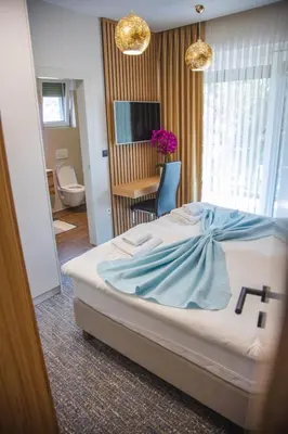 a bedroom with a bed with a blue blanket on it at Lohovo Villa Bukva in Otoka