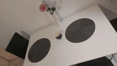 a white table with black speakers and a vase with flowers at Apartman Aladin in Bihać