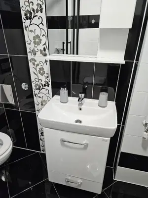 a bathroom with a white sink and a toilet at Apartman Aladin in Bihać