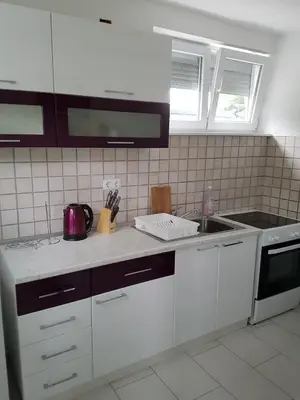 a kitchen with white cabinets and a sink at Apartman Aladin in Bihać