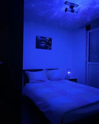 a blue bedroom with a bed with a camera on the ceiling at Apartman/Stan na dan Teslić in Teslić