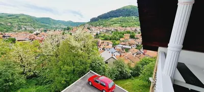 a red car parked on a balcony of a town at VISOKO Room in Visoko