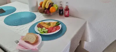 a table with a plate of food and a bowl of fruit at VISOKO Room in Visoko