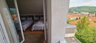 a room with two beds and a view of a city at VISOKO Room in Visoko