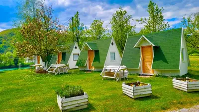 a row of cottages on a grassy field at Una Kamp in Bosanska Krupa