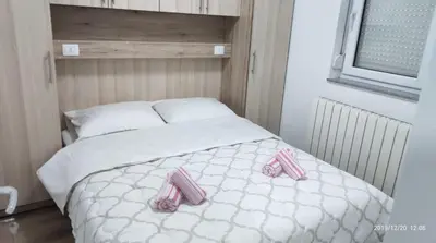 a bedroom with a bed with pink shoes on it at Apartmani Čiča in Kupres
