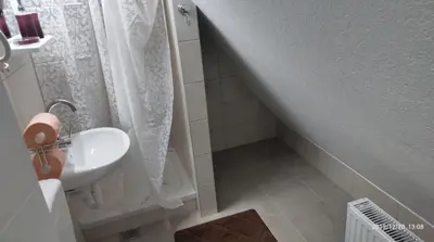 a bathroom with a sink and a shower at Apartmani Čiča in Kupres