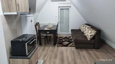 a small living room with a couch and a table at Apartmani Čiča in Kupres