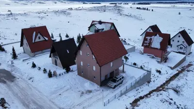 an aerial view of a house in the snow at Apartmani Čiča in Kupres