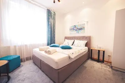 a bedroom with a large bed with blue pillows at Central Square Apartment in Banja Luka