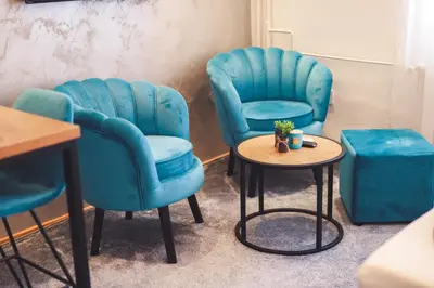 two blue chairs and a table in a room at Central Square Apartment in Banja Luka