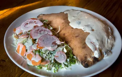 a plate of food on a wooden table at Apartmani Di Casa Dreams in Donji Vakuf