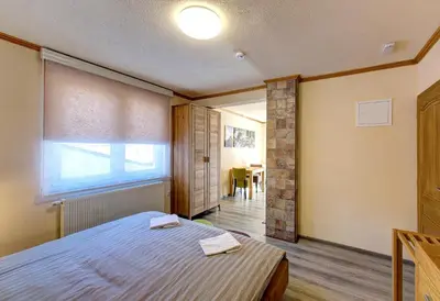 a bedroom with a bed and a window and a table at Apartmani Di Casa Dreams in Donji Vakuf