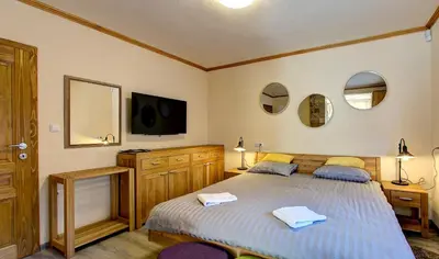 a bedroom with a bed and a tv and mirrors at Apartmani Di Casa Dreams in Donji Vakuf