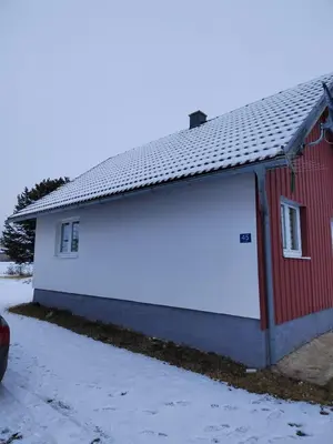 a red and white building with a white garage at Kuca za odmor Marija in Kupres