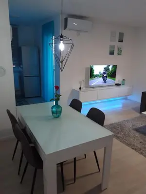 a dining room with a white table and chairs at Elena apartmani Tuzla in Tuzla