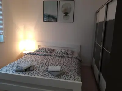 a bedroom with a bed with two pillows on it at Elena apartmani Tuzla in Tuzla