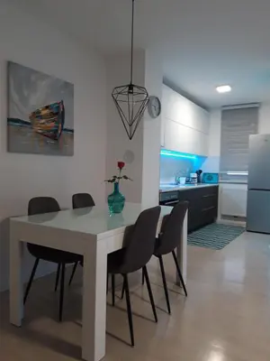 a kitchen and dining room with a table and chairs at Elena apartmani Tuzla in Tuzla
