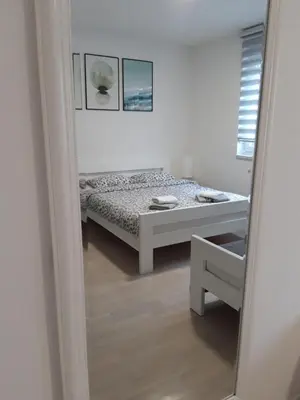 a bedroom with a bed and a mirror at Elena apartmani Tuzla in Tuzla