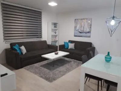 a living room with a couch and a table at Elena apartmani Tuzla in Tuzla