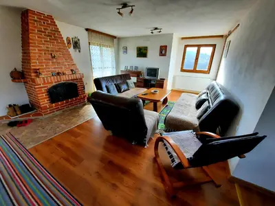 a living room with leather furniture and a fireplace at Kuća na dan Vrla strana in Bosansko Petrovo Selo