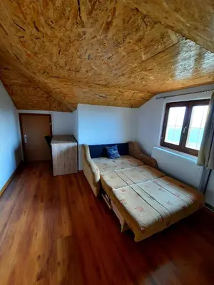 a bed in a room with a wooden ceiling at Kuća na dan Vrla strana in Bosansko Petrovo Selo