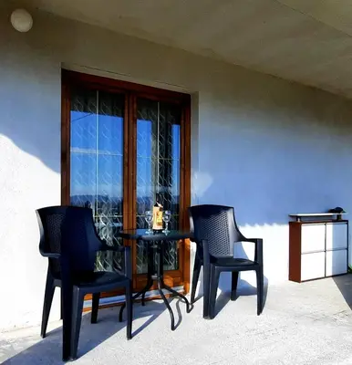 a table and chairs in front of a window at Kuća na dan Vrla strana in Bosansko Petrovo Selo