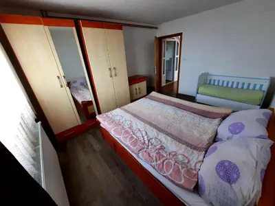 a small bedroom with a bed and a mirror at Kuća na dan Vrla strana in Bosansko Petrovo Selo