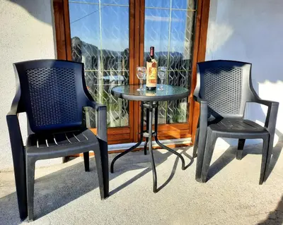 two chairs and a table with a bottle of wine at Kuća na dan Vrla strana in Bosansko Petrovo Selo