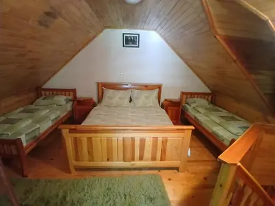 a bedroom with two beds in a attic at Apartmani i sobe 