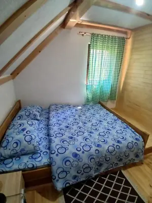 a small bed in a small room with a window at Apartmani i sobe 