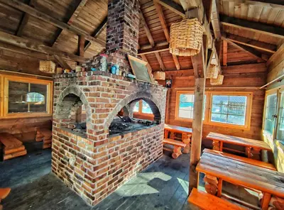 a brick fireplace in a room with benches and windows at APARTMAN SNOW Vlašić in Vlasic