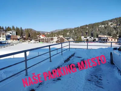 a snow covered parking lot with a sign that readsmission parking museum at APARTMAN SNOW Vlašić in Vlasic